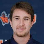 Jordan Lambert stands in front of Utica Pioneers background.