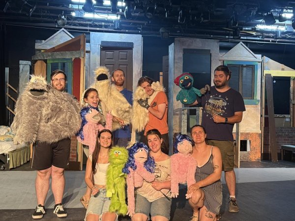 Members of the cast and their puppet companions on the stage in Strebel Auditorium for Avenue Q.