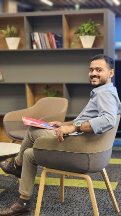 Ashham Saleel in a chair, looking at the camera and smiling.