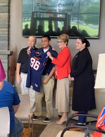 Jacob Phelps, son of the late Thomas Phelps, accepts an honorary jersey on behalf of his late father.