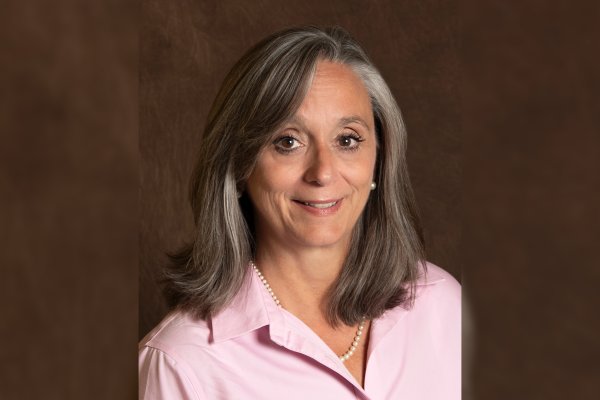 Patricia “Patty” Montone Charvat 'in a pink shirt smiles at the camera.